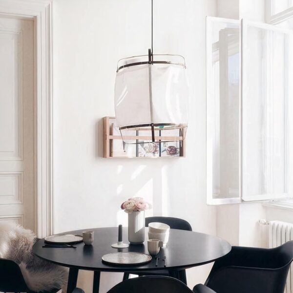 Hängeleuchte aus weißem Leinen und Design in einem Esszimmer über einem schwarzen runden Tisch