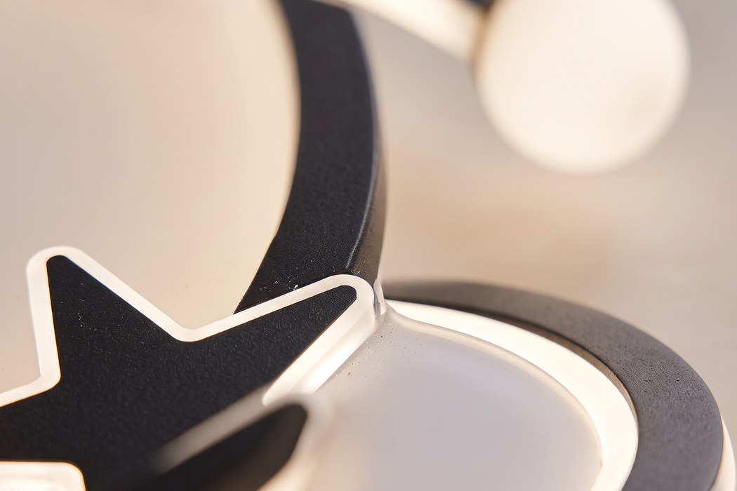 Makroaufnahme des Sterns aus schwarzem Acryl, des lichtdurchlässigen Monds und des lackierten Aluminiumrings