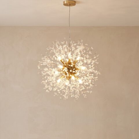 Goldener Pusteblume-Kronleuchter mit 60 cm Durchmesser, eingeschaltet vor einer beigen Wand