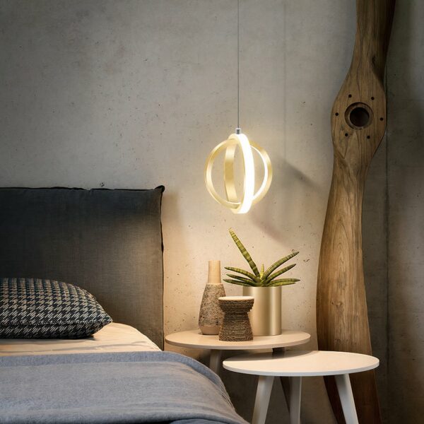 Design-Zimmerleuchte in Kugelform, bestehend aus 2 goldenen Ringen neben einem Bett