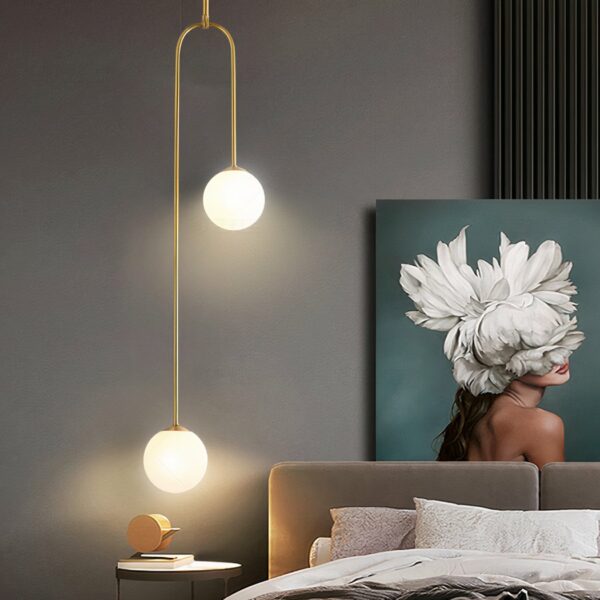 Luxuriöser Kronleuchter im modernen Stil im Erwachsenenschlafzimmer aus Acryl auf grauem Hintergrund mit einem Bild und einem Bett auf der rechten Seite