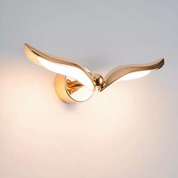 Auf einem weißen Hintergrund sehen Sie eine goldene Wandapplikation in Form eines Vogels, die eingeschaltet ist.