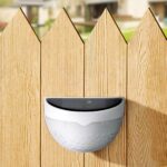 Solar-LED-Wandleuchte für den Außenbereich mit abgerundeter Form an einem Holzzaun