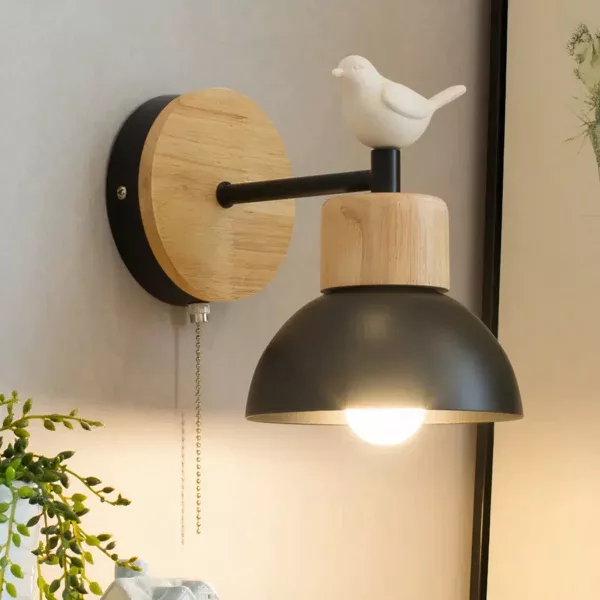 An einer Wand sehen Sie eine schwarze Wandleuchte im nordischen Stil, die mit einem weißen Vogel verziert ist.