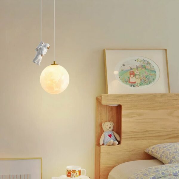 Kronleuchter de style nordique en résine avec astronaute sur fond beige avec un lit à droite