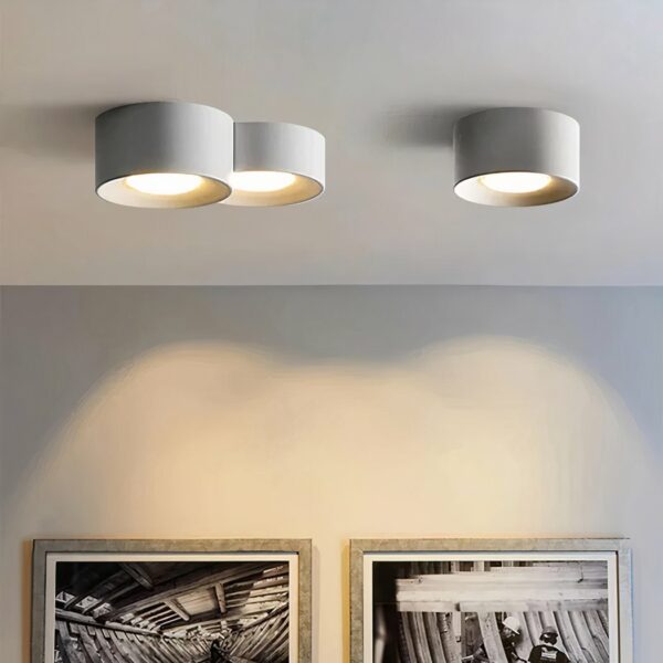 Moderner LED-Kronleuchter mit minimalistischem Zylinderdesign und Einbaustrahler in weißer Ausführung, der an der Decke befestigt und eingeschaltet wird, in einem Wohnzimmer.