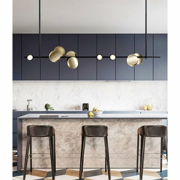 in einer modernen Küche sehen Sie eine schöne skandinavische Pendelleuchte in minimalistischem Schwarz mit goldenen Kreisen über der Arbeitsfläche