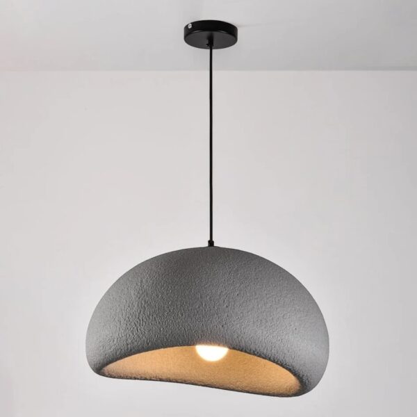 Lustre suspendu demi-sphère, finition effet pierre texturée grise, suspendu au plafond par câble fin.