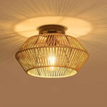 Lustre plafonnier en rotin beige ou noir de forme ronde allumé et fixé sur un plafond beige.