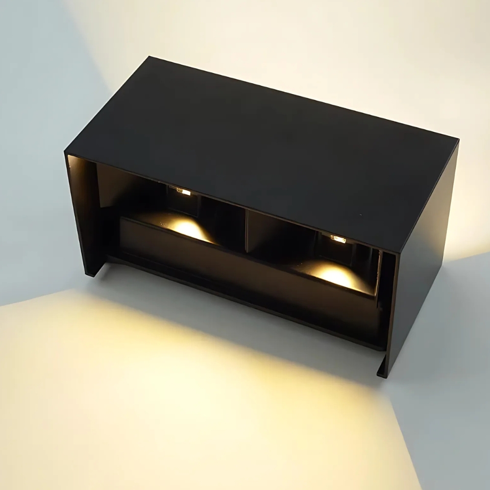 Schwarze rechteckige LED-Wandleuchte von oben fotografiert mit zwei Lichtkegeln nach unten