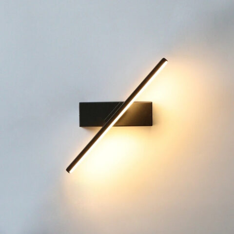 Schwarze LED-Wandleuchte mit schwenkbarem Lichtbalken an weißer Wand